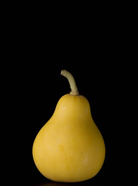 Pear-shaped decorative pumpkin on a black background