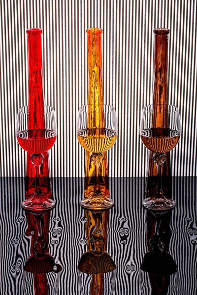 Still Life Glass Goblets Colored Bottles Background Black White Stripes — Stock Photo, Image