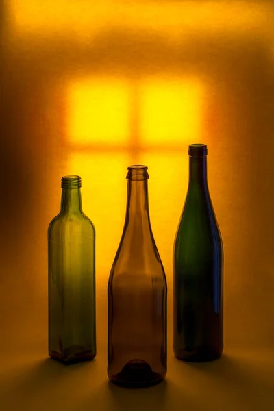 ライトアップされた窓を背景に瓶の色がついたままの生活 — ストック写真