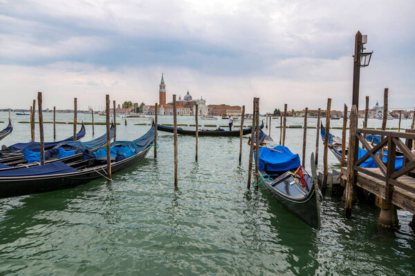 Venice, Italy - August 22, 2019: Jetty with gondolas on the Venice promenade