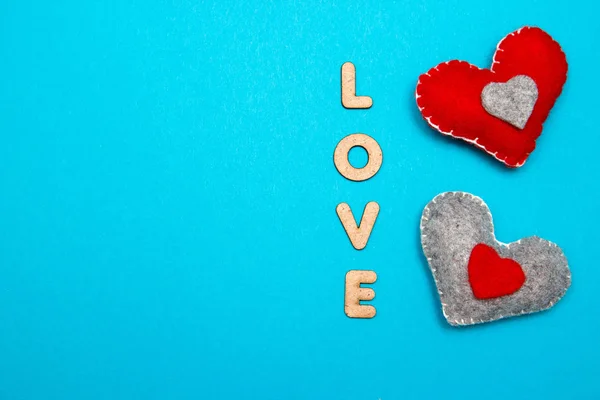 Синий фон с двумя красными сердцем и любовным словом — стоковое фото