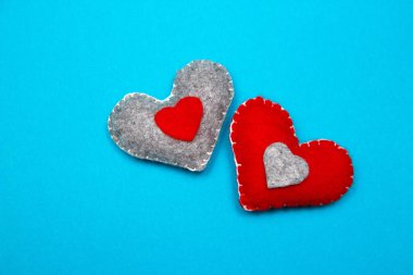 İki kırmızı mavi bir arka plan olarak el yapımı kalpler keçe. Üstten görünüm.
