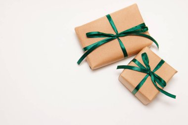 Kraft kağıt beyaz zemin üzerine yeşil bir şerit ile gelen iki hediyeler. Bayan gün.