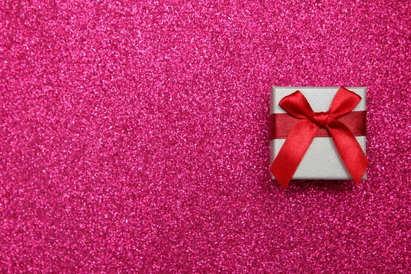 礼物粉红色的盒子在闪闪发光的粉红色的背景。祝贺礼物的概念。顶部视图, 复制空间 — 图库照片