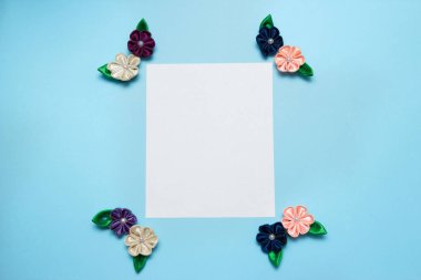 Kağıt boş saten çiçek ve kopya alanı üzerinde mavi bir arka plan ile. Üstten Görünüm, düz yatıyordu. Bahar kavramı