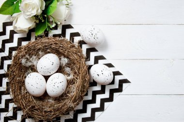 Paskalya yumurtaları çiçekli Beyaz ahşap zemin üzerinde yuva. Üstten Görünüm