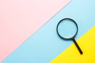 Renkli kağıda büyüteç. Üst görünüm. Arama konsepti