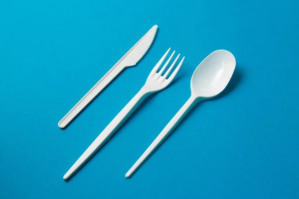 Mavi Arka Plan Üzerine Plastik Çatal, Kaşık ve Bıçak
