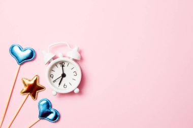 Pembe arka plan üzerinde parti dekorasyonu ile Retro çalar saat. Kopyalama alanı