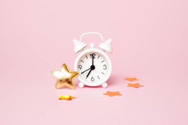 Pembe arka plan üzerinde parti dekorasyonu ile Retro çalar saat. Kopyalama alanı