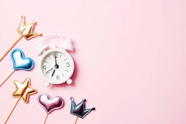 Pembe arka plan üzerinde parti dekorasyonu ile Retro çalar saat. Kopyalama alanı