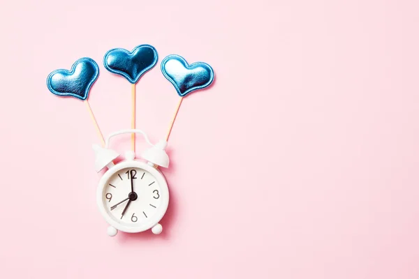 Reloj despertador retro con decoración de fiesta sobre fondo rosa. Copiar espacio — Foto de Stock
