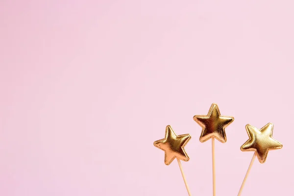 Drie glanzende sterren op een roze achtergrond. Decoraties voor vakantie feest. Ruimte kopiëren — Stockfoto