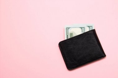 Pembe arka planda para olan siyah deri cüzdan. Üstte görüntü