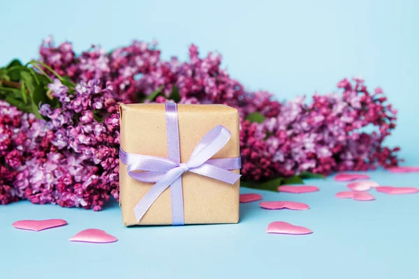 Quadro de flores lilás com caixa de presente em um fundo azul. Dia das mães . — Fotografia de Stock