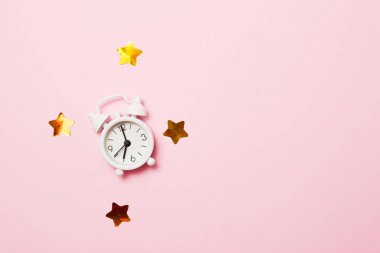 Pembe arka plan üzerinde parti dekorasyonu ile Retro çalar saat. Kopya alanı, üst görünüm