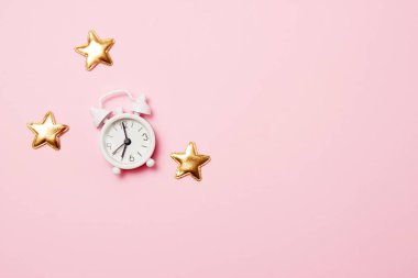 Pembe arka plan üzerinde parti dekorasyonu ile Retro çalar saat. Kopya alanı, üst görünüm