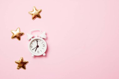 Pembe arka plan üzerinde parti dekorasyonu ile Retro çalar saat. Kopya alanı, üst görünüm