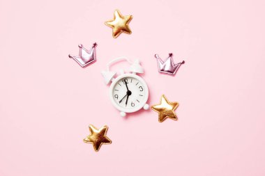 Pembe arka plan üzerinde parti dekorasyonu ile Retro çalar saat. Kopya alanı, üst görünüm