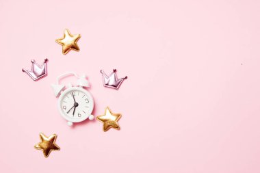 Pembe arka plan üzerinde parti dekorasyonu ile Retro çalar saat. Kopya alanı, üst görünüm
