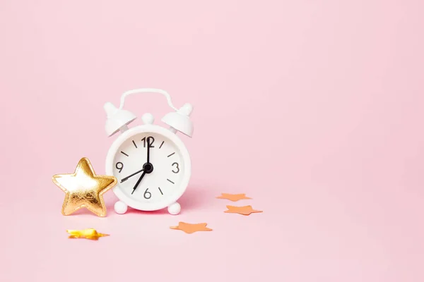 Reloj despertador retro con decoración de fiesta sobre fondo rosa. Copiar espacio — Foto de Stock