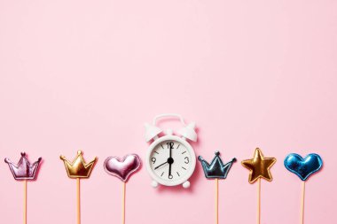 Pembe arka plan üzerinde parti dekorasyonu ile Retro çalar saat. Kopya alanı, üst görünüm