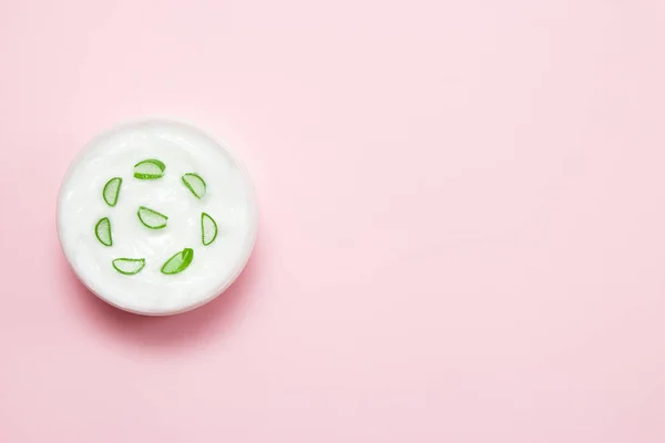 Tarro de crema y rebanada de aloe vera sobre fondo rosa. Vista superior — Foto de Stock