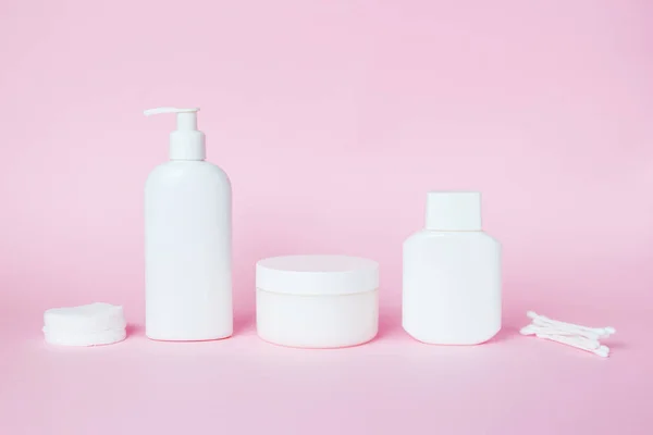 Frascos brancos de cosméticos em um contexto rosa. Acessórios de banho. Conceito de rosto e cuidados corporais — Fotografia de Stock