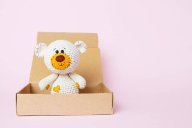 Pembe bir arka plan üzerinde izole edilmiş bir zanaat kutusunda oyuncak oyuncak ayı. Bebek arka planı. Kopya alanı, üst görünüm