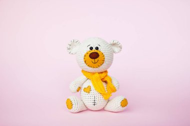 Amigurumi el yapımı oyuncak ayı pembe bir arka plan üzerinde izole. Bebek arka planı. Kopyalama alanı