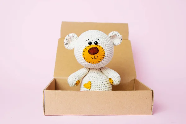 Nounours jouet dans une boîte artisanale isolée sur un fond rose. Fond bébé. Espace de copie, vue du dessus — Photo