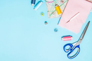 Mavi arka plan, dikiş, nakış üzerinde dikiş malzemeleri, desen ve aksesuarları. metin alanı. düz yatıyordu, üst görünüm. Arka plan dikmek. Terzici ve tasarım masası