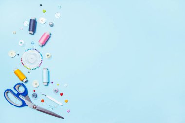 Mavi arka plan, dikiş, nakış üzerinde dikiş malzemeleri, desen ve aksesuarları. metin alanı. düz yatıyordu, üst görünüm. Arka plan dikmek. Terzici ve tasarım masası.