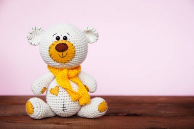 Pembe bir arka plan üzerinde Amigurumi el yapımı oyuncak ayı. Bebek arka planı. Kopyalama alanı
