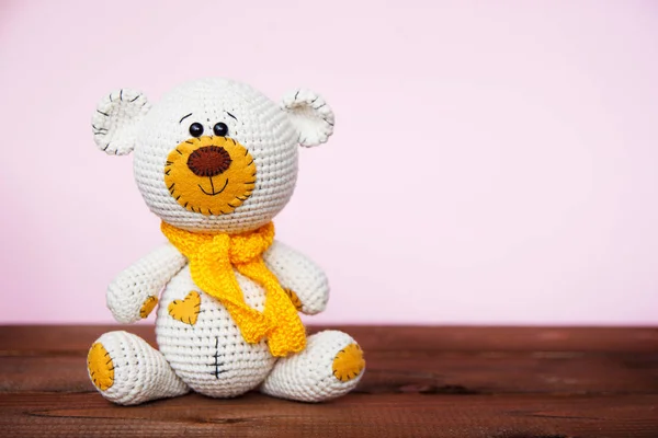 Pembe bir arka plan üzerinde Amigurumi el yapımı oyuncak ayı. Bebek arka planı. Kopyalama alanı