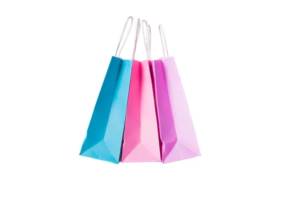 Trzy papierowe różowe, fioletowe, niebieskie torby na zakupy na białym tle. Widok z góry. — Zdjęcie stockowe