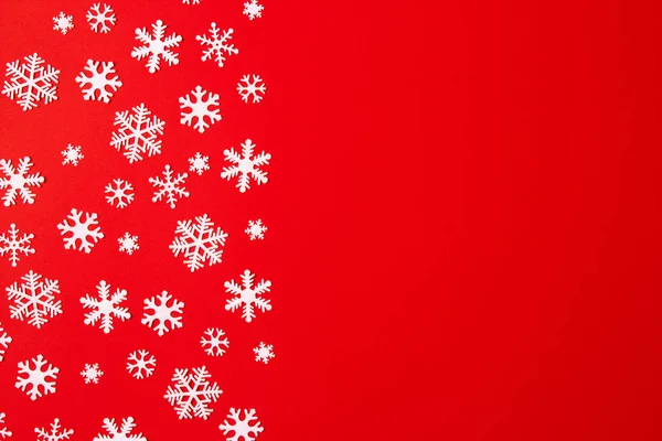 Arreglo creativo de la decoración de Navidad copos de nieve sobre fondo rojo. Concepto de vacaciones. Piso tendido, vista superior . — Foto de Stock