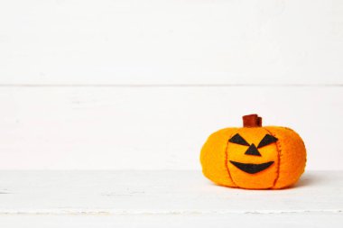 Halloween sevimli turuncu el yapımı kopya alanı ile eski bir beyaz ahşap arka plan üzerinde kabak keçe. Cadılar Bayramı çocuklar zanaat arka plan. Ev keçe kabak dekor