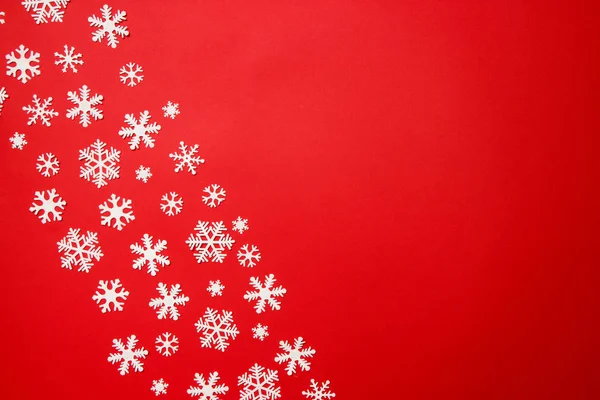 Arreglo creativo de la decoración de Navidad copos de nieve sobre fondo rojo. Concepto de vacaciones. Piso tendido, vista superior — Foto de Stock