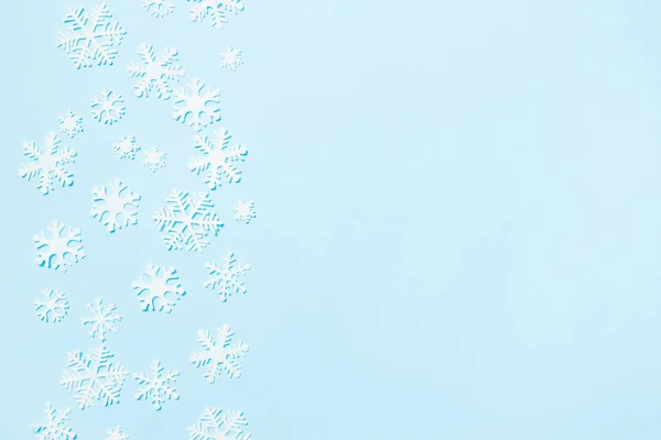 Arreglo creativo de la decoración de Navidad copos de nieve sobre fondo azul. Concepto de vacaciones. Piso tendido, vista superior . — Foto de Stock