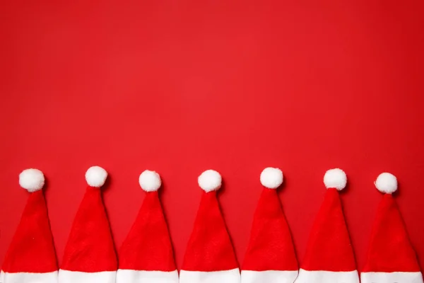 Noel ve Yeni Yıl tatil arka plan. Kırmızı arka planda Noel Baba şapkaları. Metin için yer