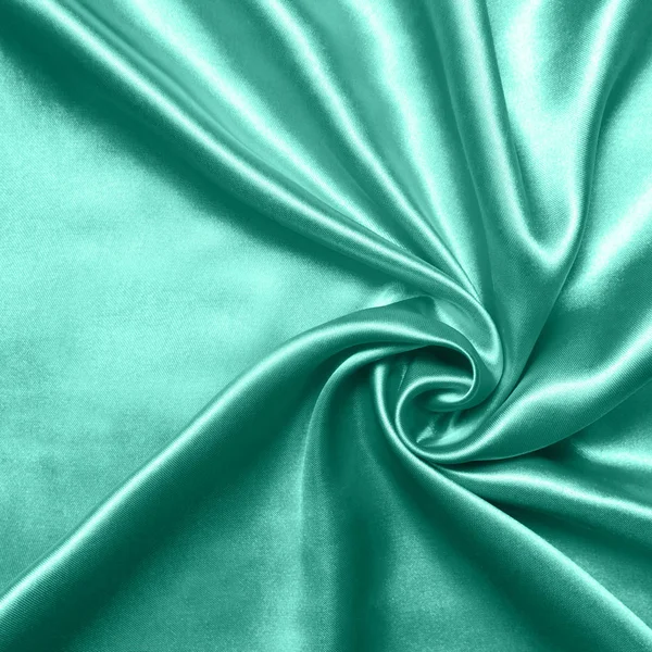 Közeli fel hullámai a selyem szövet. Szatén textil háttér. Zöld szín. Felülnézet. Az év színe 2020 — Stock Fotó