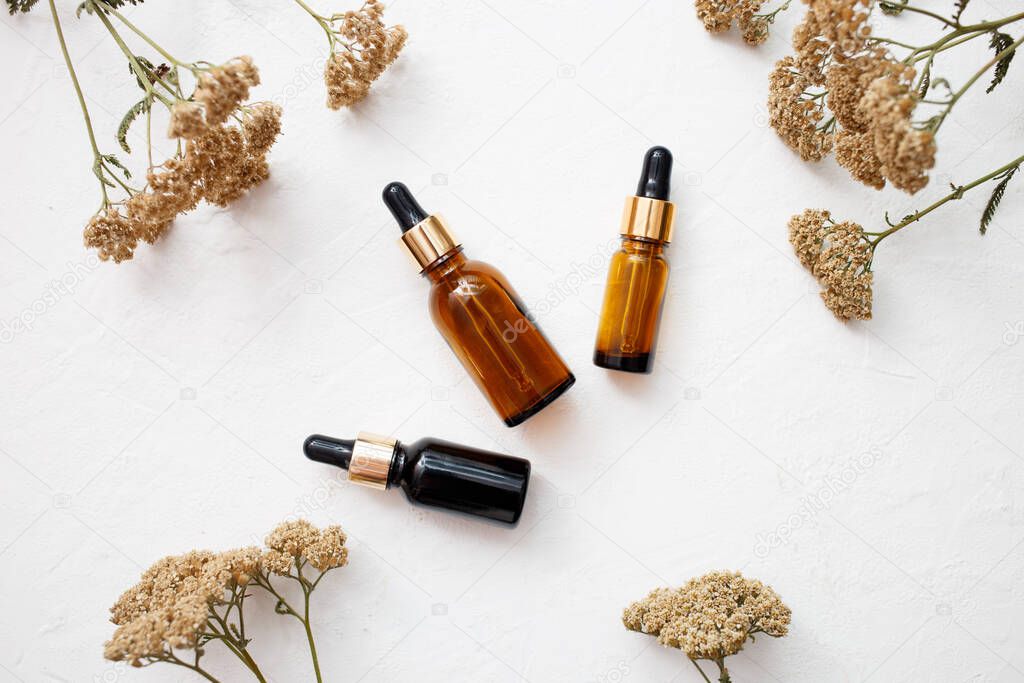 Flat lay of droppers glass bottle skincare essential oil products for mock up in minimal style with on white background