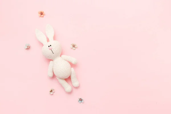 用粉红色背景隔离的花朵编织的兔子之友 婴儿背景 复制空间 顶部视图 — 图库照片