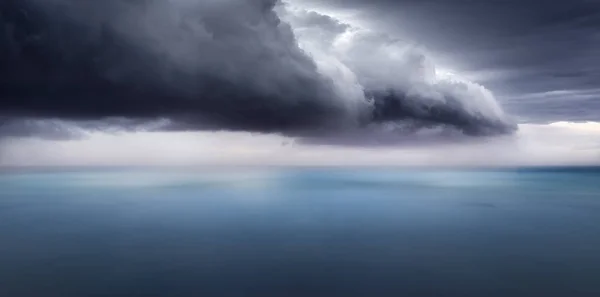 A dark storm cloud over the ocean