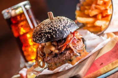Kola ve patates kızartması arka planda siyah Cuma için siyah burger. Arka plan olarak koyu ahşap masa
