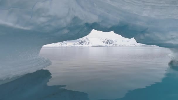 Antarctica shot through iceberg arch. — Stock Video