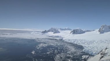 Hava uçuş Antarktika buzul kıyı üzerinde. İklim değişikliği. Kar, buz kaplı dağlar kara. Buzun içinde donmuş kutup okyanus parçaları. Kış Antarktika manzara. Vahşi bakir ortam. 4k