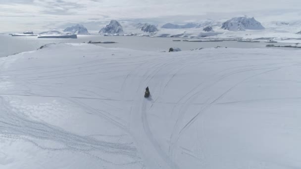Vol aérien au-dessus de motoneiges en mouvement. Antarctique .