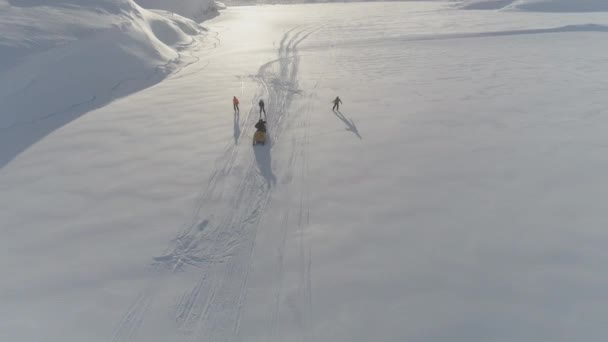 Ski-doo pull Skifahren auf Schnee oberflächliche Luftaufnahme — Stockvideo